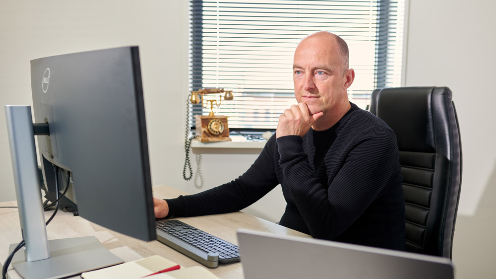 Jan van den Berg achter de computer